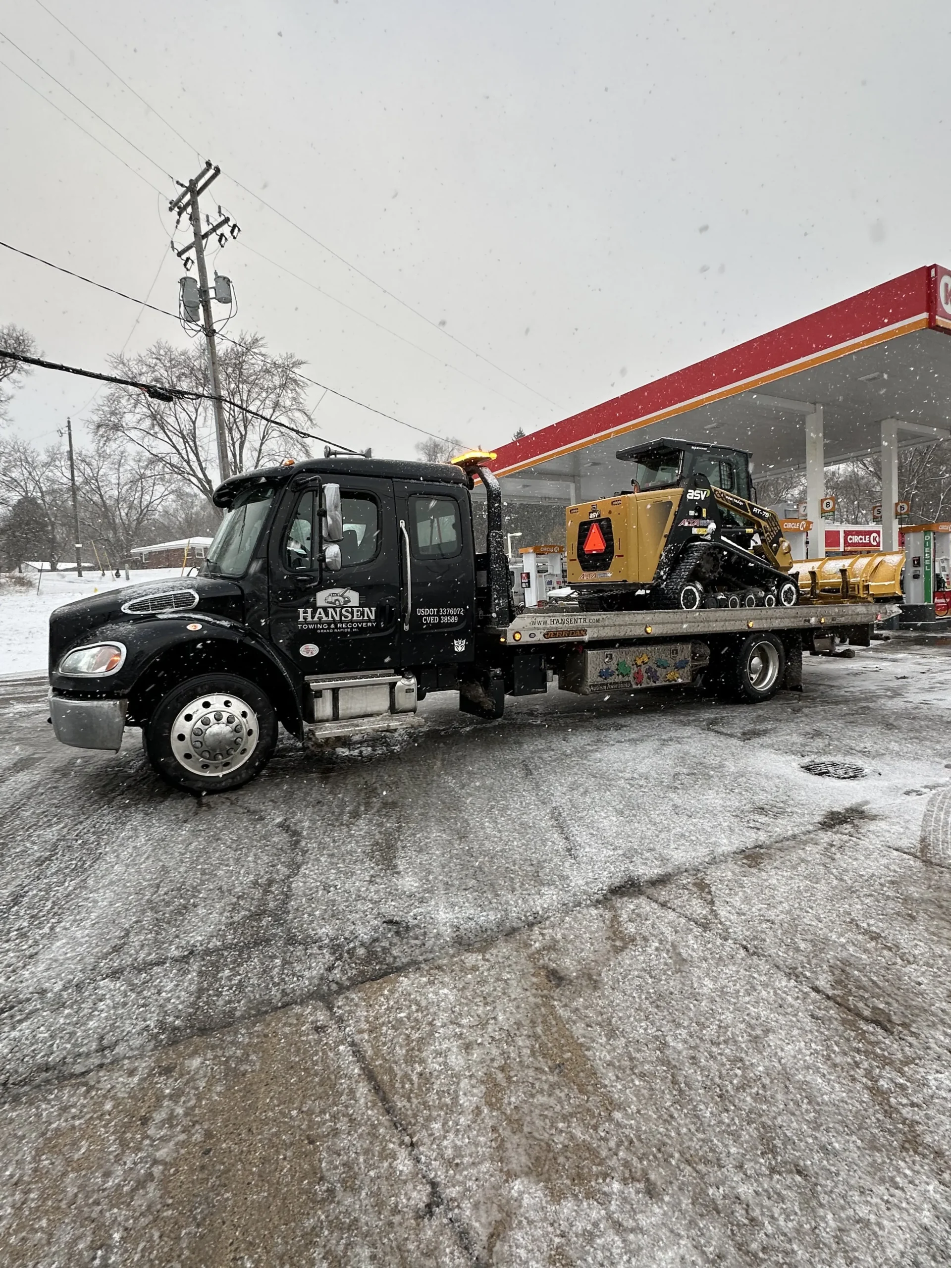 Skid steer being transported to its next job site in Kent County, MI by Hansen Towing & Recovery.