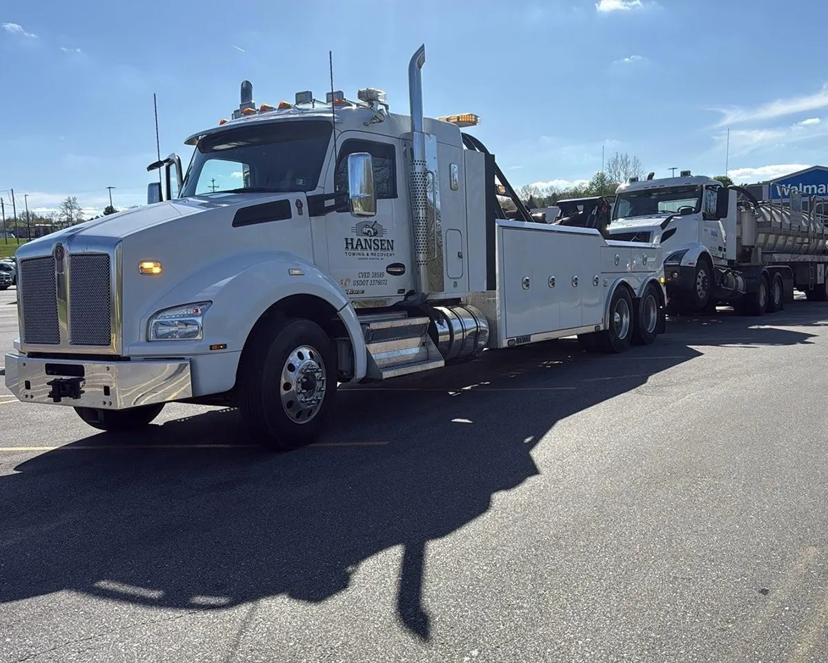 Hansen Towing & Recovery’s heavy-duty wrecker recovering a broken down semi with a vacuum trailer from a Walmart parking lot in Hastings, MI.
